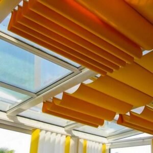 Room with yellow curtains and a skylight, where skylight shades are used to regulate the brightness of the room.