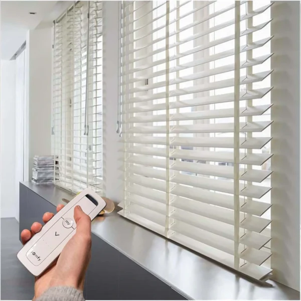 Individual using remote control in room featuring Smart Motorized Wooden Blind.