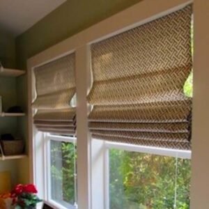 A window with Roman shades and a shelf holding a vase.