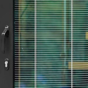 A window featuring integral blinds and a sleek door handle, showcasing a modern design element in a well-lit space.